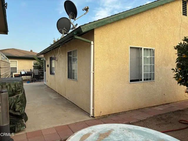a backyard of a house with table and chairs