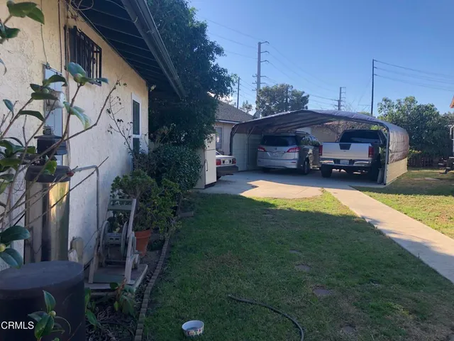 a view of a house with backyard and sitting area