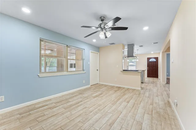 a view of empty room with wooden floor and windows
