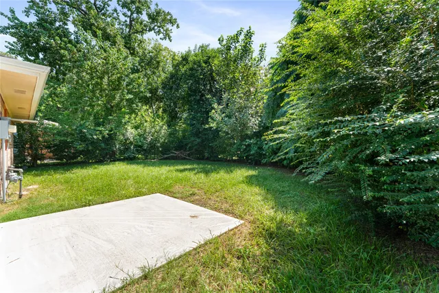 a view of a backyard with a garden and entertaining space