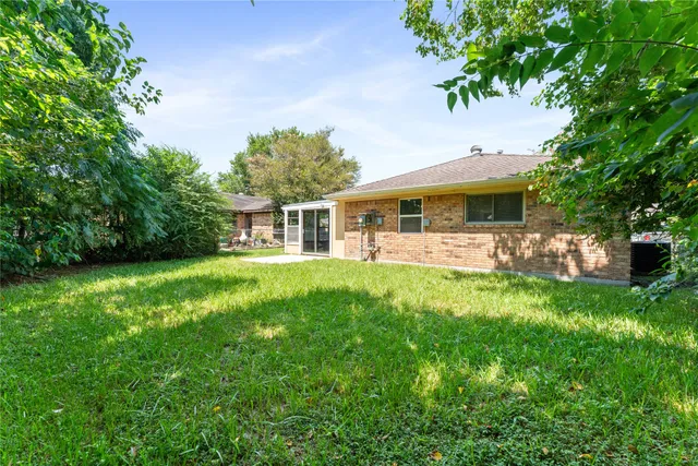 a view of house with backyard outdoor seating and green space