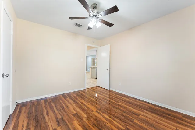 an empty room with a window and ceiling fan