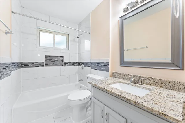 a bathroom with a granite countertop tub sink and mirror