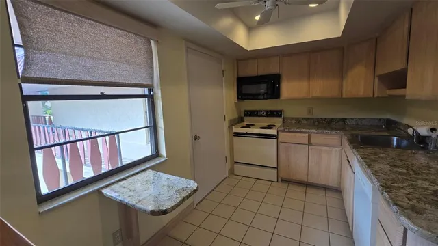 a kitchen with granite countertop cabinets and white appliances