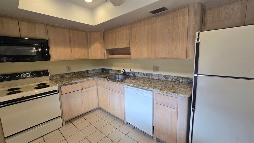 88 Boundary Boulevard, Unit 149 Rotonda West, FL 33947 - Photo 14 of 40 a kitchen with granite countertop cabinets and white appliances
