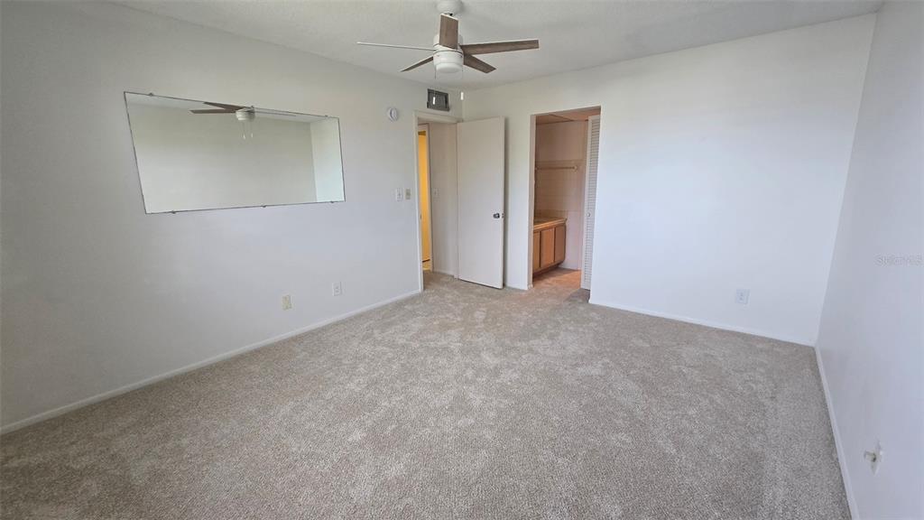 88 Boundary Boulevard, Unit 149 Rotonda West, FL 33947 - Photo 25 of 40 an empty room with chandelier fan and windows