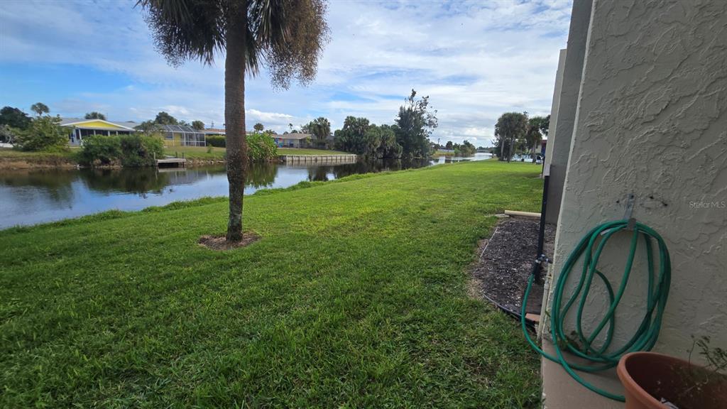 88 Boundary Boulevard, Unit 149 Rotonda West, FL 33947 - Photo 32 of 40 a backyard of a house with lots of green space and lake view