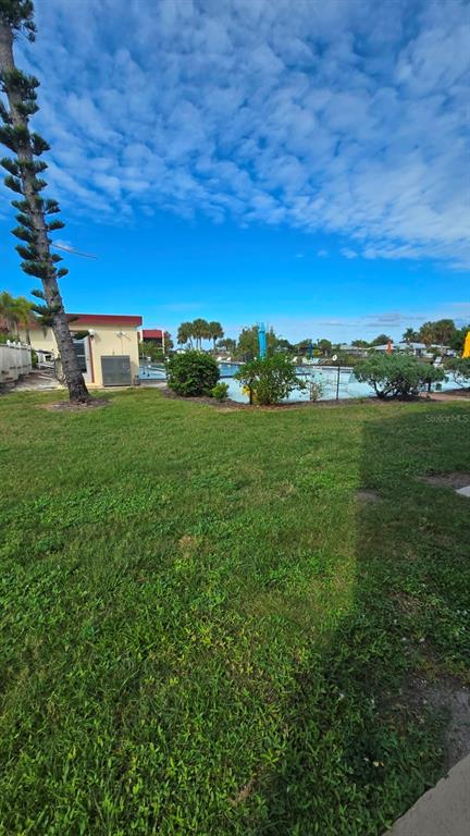 88 Boundary Boulevard, Unit 149 Rotonda West, FL 33947 - Photo 36 of 40 a view of a big yard with a building in the background