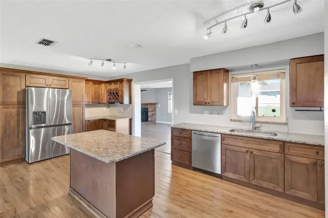 a kitchen with stainless steel appliances granite countertop a sink stove and refrigerator