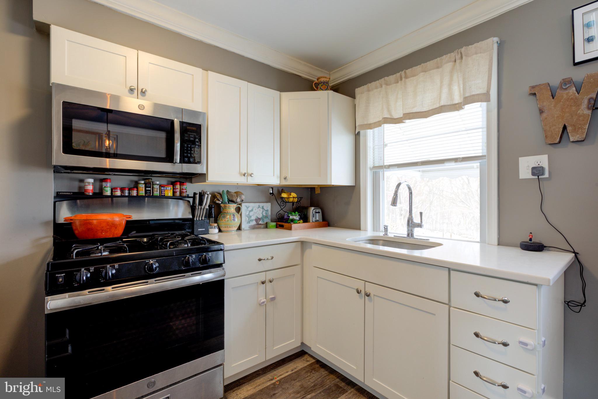 203 Overlook Road Philadelphia, PA 19128 - Photo 12 of 32 a kitchen with stainless steel appliances a stove a microwave a sink and cabinets