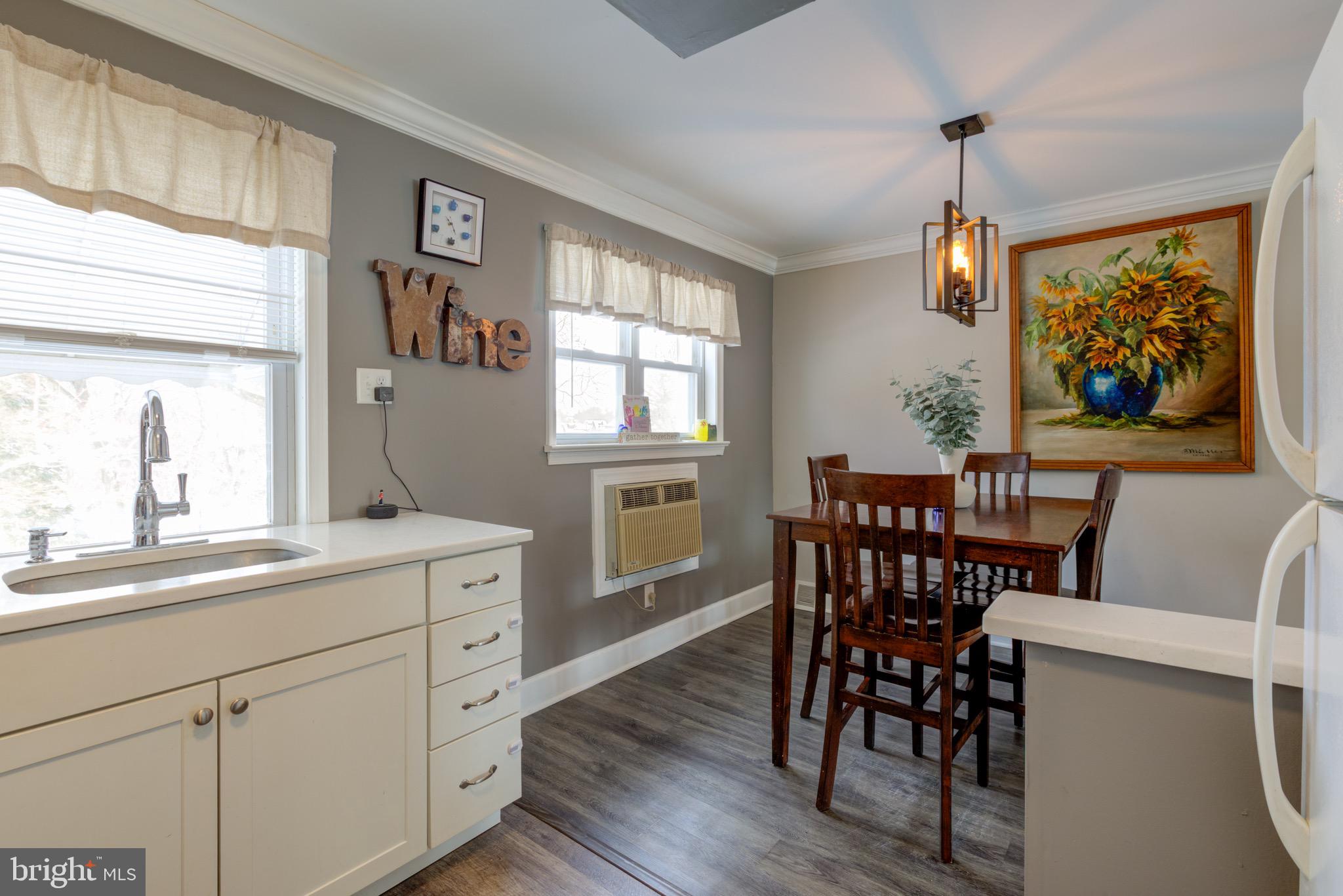 203 Overlook Road Philadelphia, PA 19128 - Photo 13 of 32 a dining room with wooden floor a chandelier a wooden table and chairs