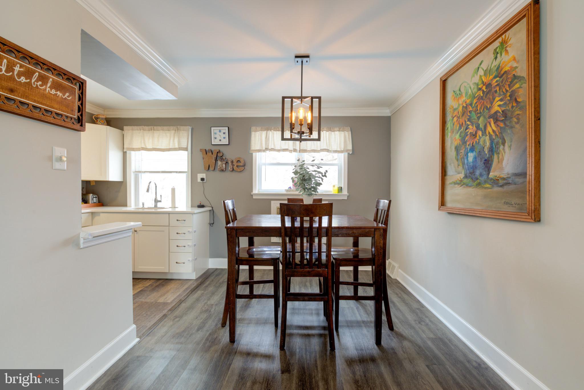 203 Overlook Road Philadelphia, PA 19128 - Photo 7 of 32 a dining room with wooden floor a chandelier a wooden table and chairs