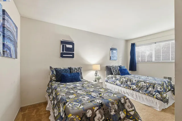 a bedroom with two beds and a lamp