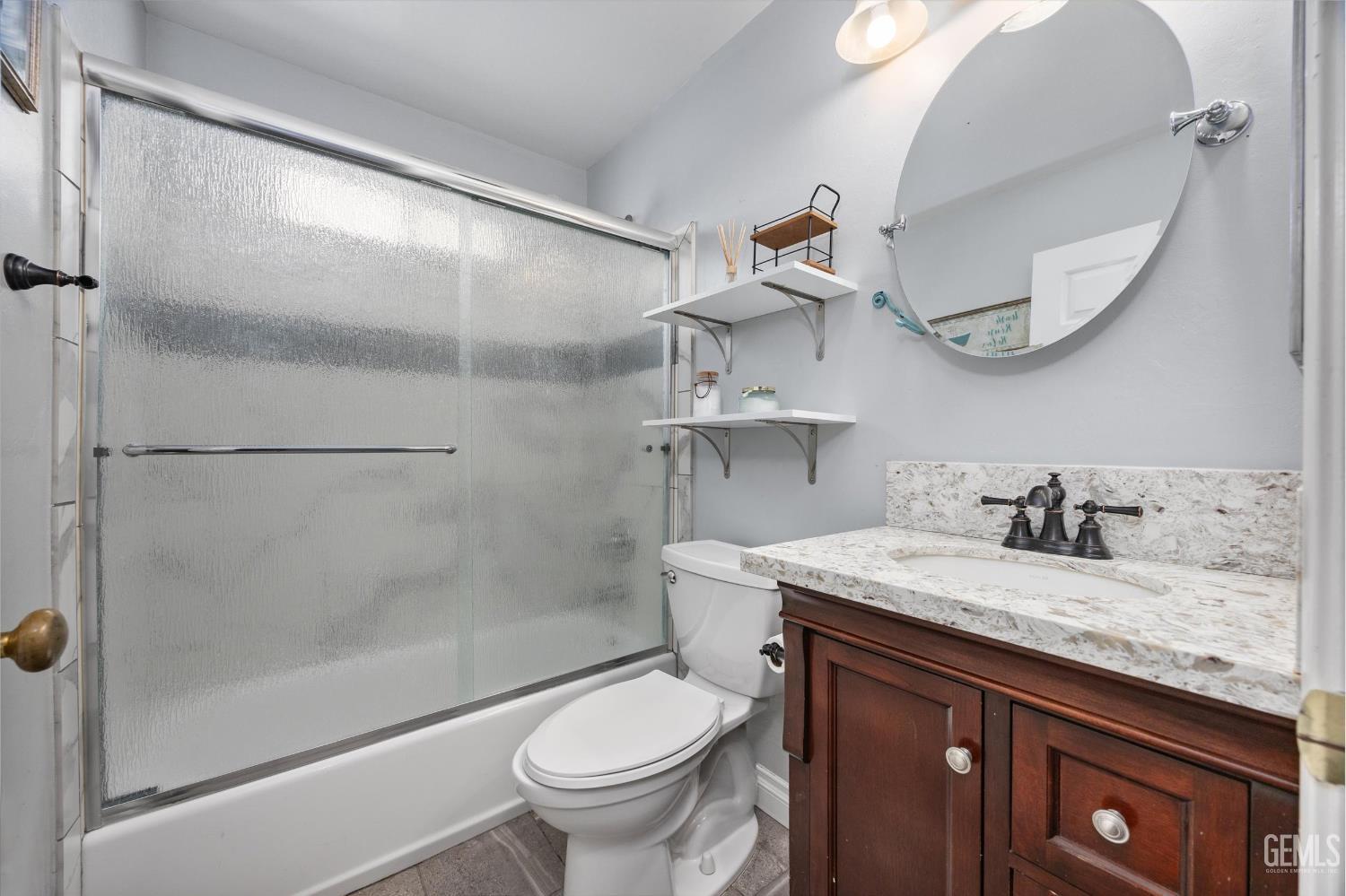 Undisclosed Address Bakersfield, CA 93301 - Photo 18 of 30 a bathroom with a granite countertop sink toilet and shower