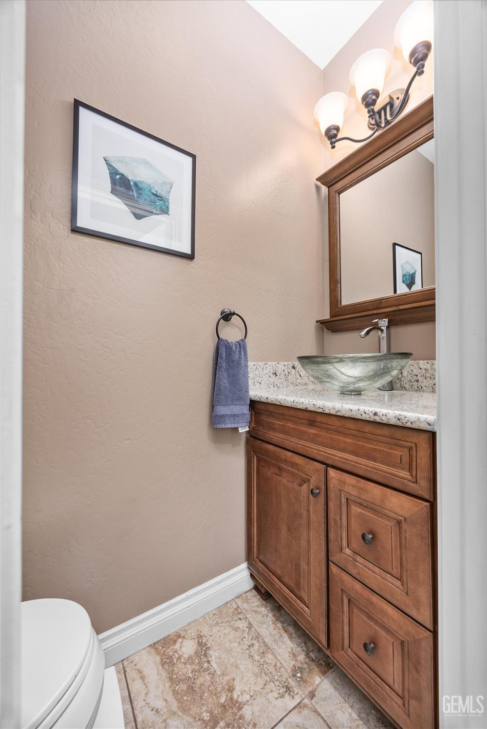 Undisclosed Address Bakersfield, CA 93301 - Photo 25 of 30 a bathroom with a granite countertop sink and a mirror