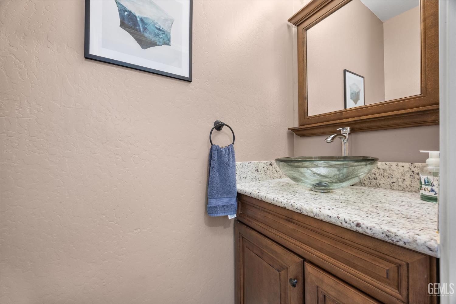 Undisclosed Address Bakersfield, CA 93301 - Photo 26 of 30 a bathroom with a granite countertop sink and a mirror