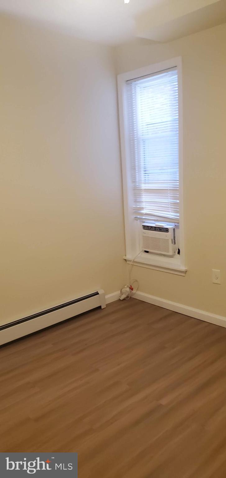 5921 Chancellor Street Philadelphia, PA 19139 - Photo 6 of 12 an empty room with wooden floor and windows