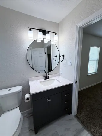 a bathroom with a toilet sink and mirror