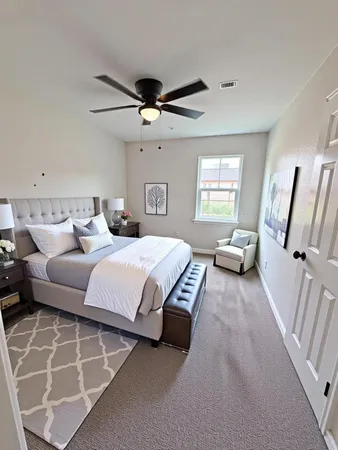 a bedroom with furniture and a large window