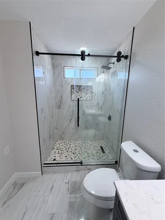 a bathroom with a toilet and a shower