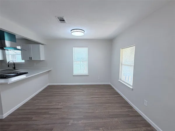 a view of a kitchen with wooden floor and a sink