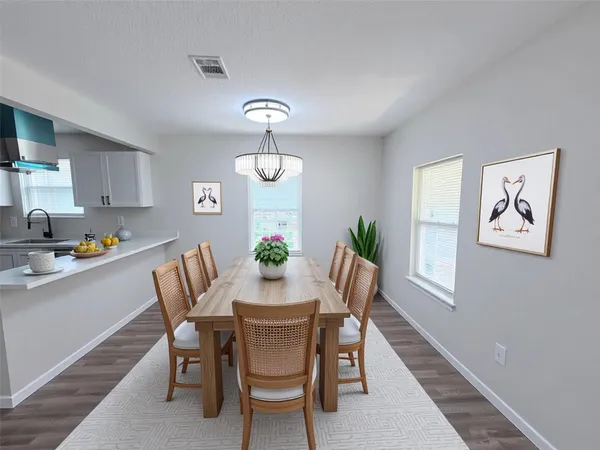 a view of a dining room with furniture a rug and wooden floor