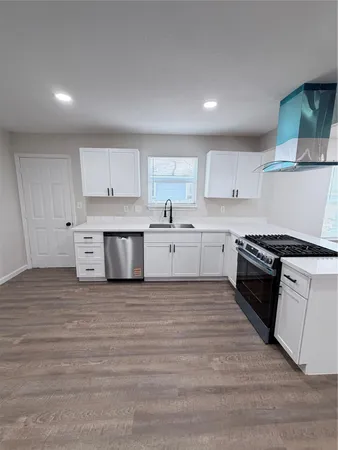 a large kitchen with stainless steel appliances granite countertop a stove and a sink