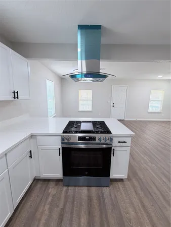a stove top oven sitting inside of a kitchen