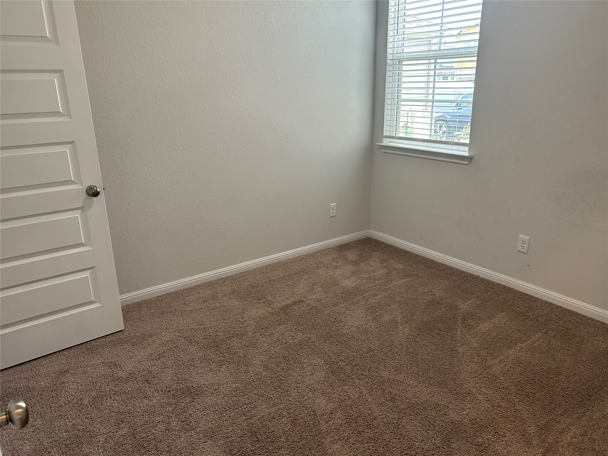 118 Two Bits Lane Elgin, TX 78621 - Photo 10 of 23 Soft carpeting pairs with a multi-paneled door in this versatile secondary bedroom space.