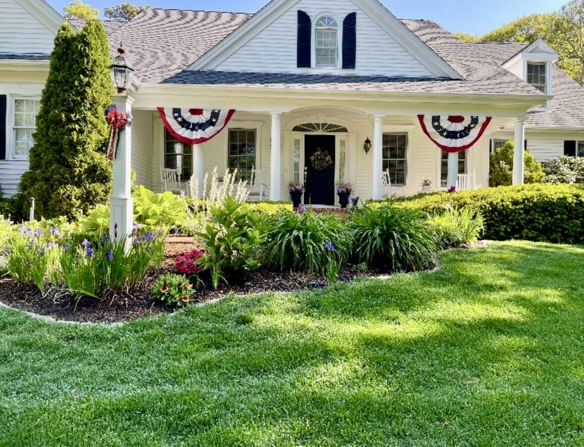 201 Forest Street Harwich, MA 02645 - Photo 2 of 59 a bunch of flowers in front of a house