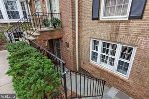 a view of a brick house with wooden stairs and windows