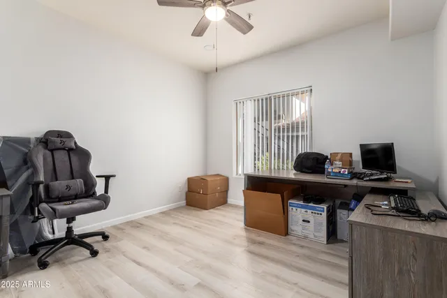 a view of a workspace with furniture and a window