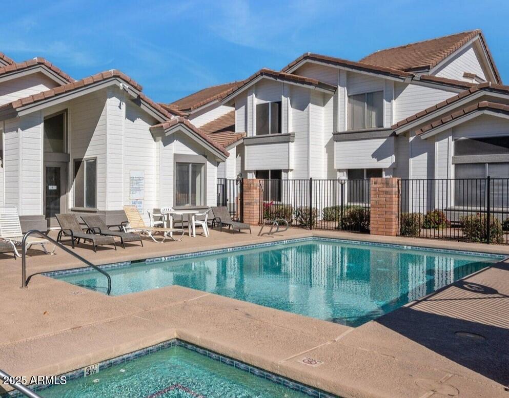 2201 North Comanche Drive, Unit 1080 Chandler, AZ 85224 - Photo 16 of 18 a view of a house with pool lawn chairs and a dining table under an umbrella