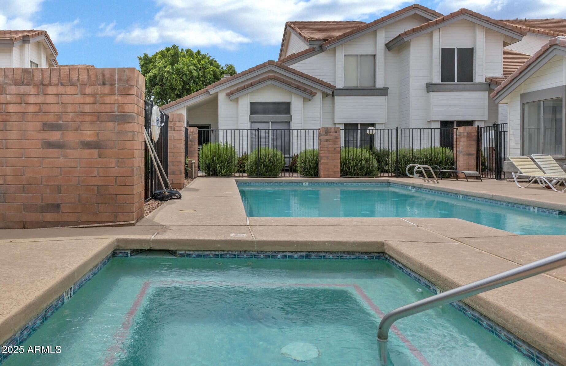 2201 North Comanche Drive, Unit 1080 Chandler, AZ 85224 - Photo 17 of 18 a view of a white house next to a yard with potted plants