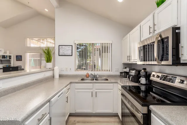 a kitchen with a sink stove top oven and cabinets