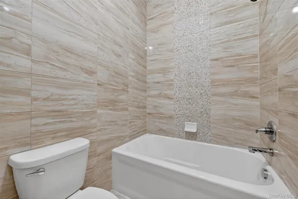 a view of an empty room with closet and a window