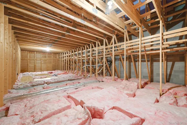 a view of a hallway with wooden floor and a bathroom