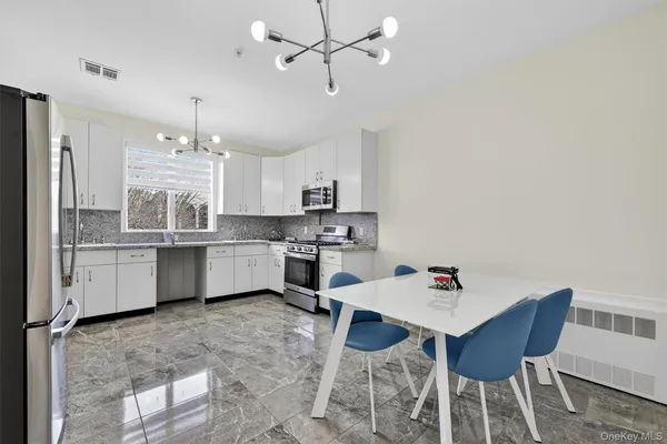 a kitchen with a dining table chairs sink and cabinets