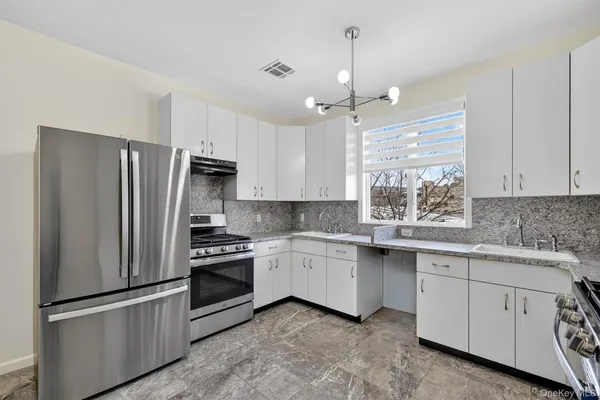 a kitchen with a sink stainless steel appliances and window