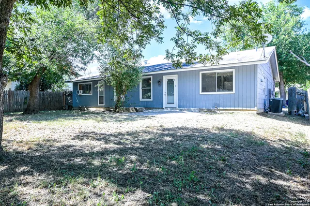a backyard of a house with table and chairs