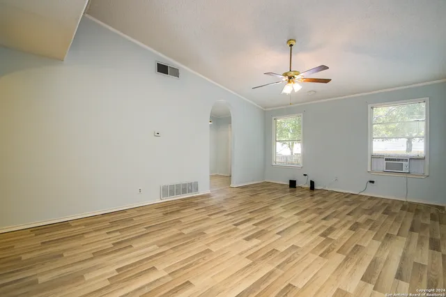 a view of empty room with window and ceiling fan