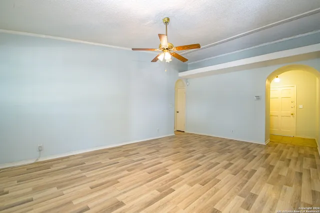 a view of a room with a ceiling fan and wooden floor
