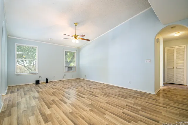 a view of a bedroom with wooden floor and windows