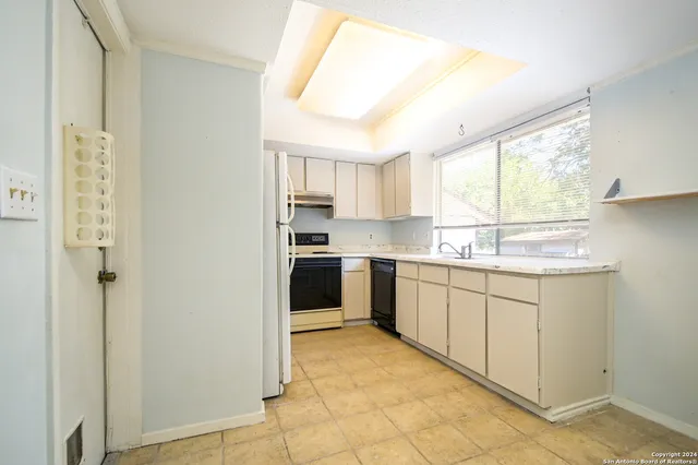 a kitchen with granite countertop white cabinets and white appliances