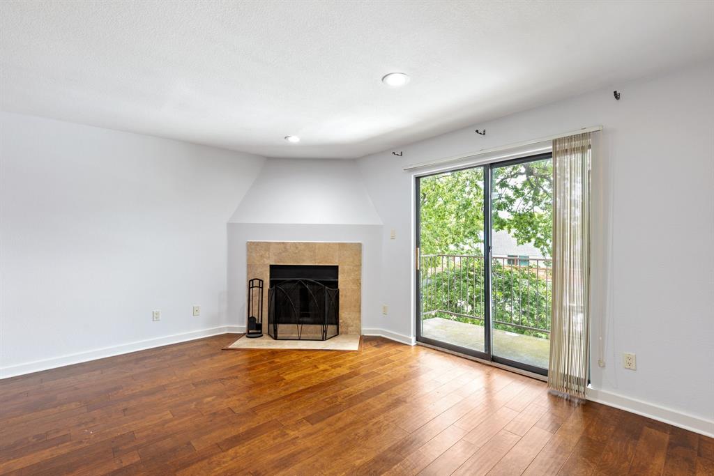 4777 Cedar Springs Road, Unit 6N Dallas, TX 75219 - Photo 10 of 24 an empty room with wooden floor fireplace and windows