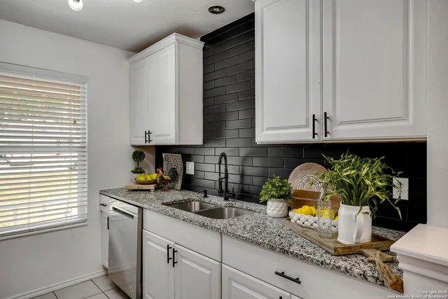 a kitchen with stainless steel appliances granite countertop a sink a stove and a granite counter tops