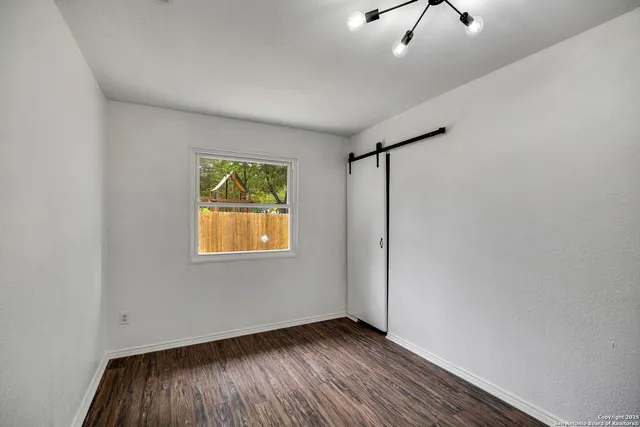 a view of room with window and wooden floor