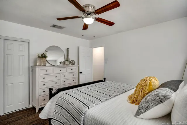 a bedroom with a bed a chandelier and dresser