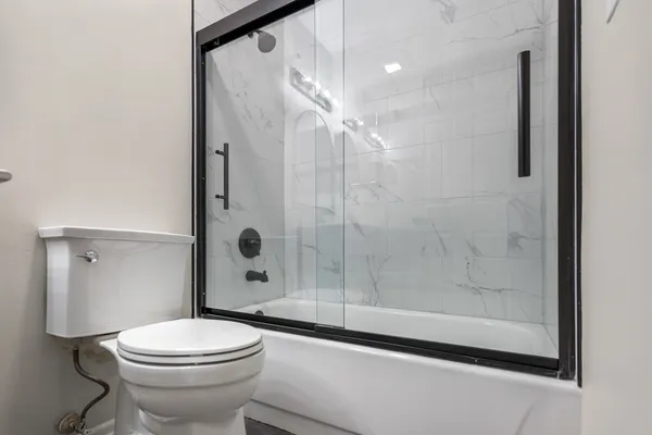 a bathroom with a shower a toilet and a window