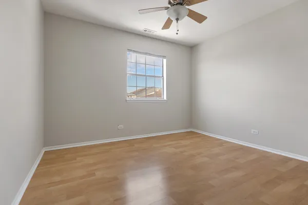 an empty room with a window and a fan